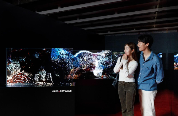 LG디스플레이 모델이 서울 성수동 복합문화공간 '쎈느'에서 열리는 '아트 웨이브' 전시회에서 OLED로 구현한 디지털아트 작품을 관람하고 있다. [사진=LG디스플레이 ]