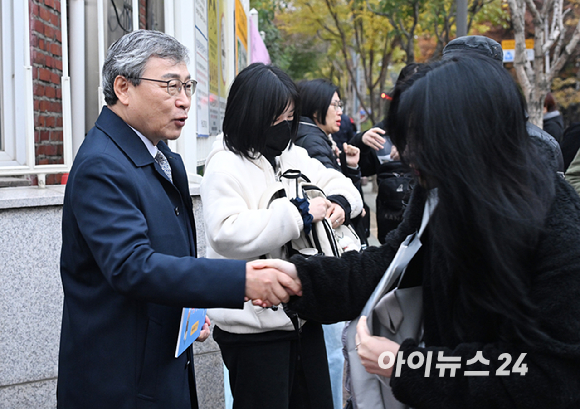 정근식 서울시교육감이 2026학년도 대학수학능력시험일인 13일 오전 서울 광진구 광남고등학교 입구에서 수험생들을 응원하며 악수하고 있다. [사진=사진공동취재단]