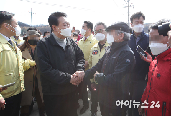 윤석열 대통령 당선인이 15일 경북 울진군 북면 검성리 산불피해현장을 방문해 피해지역 주민들과 인사하고 있다. [사진=국회사진취재단]