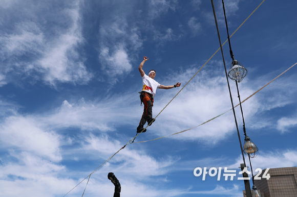 세계적인 슬랙라인 선수 얀 루스(Jaan Roose)가 1일 서울 광화문 사거리 상공 120m 높이에서 '레드불 서울 줄타기' 퍼포먼스를 선보이고 있다. [사진=정소희 기자]