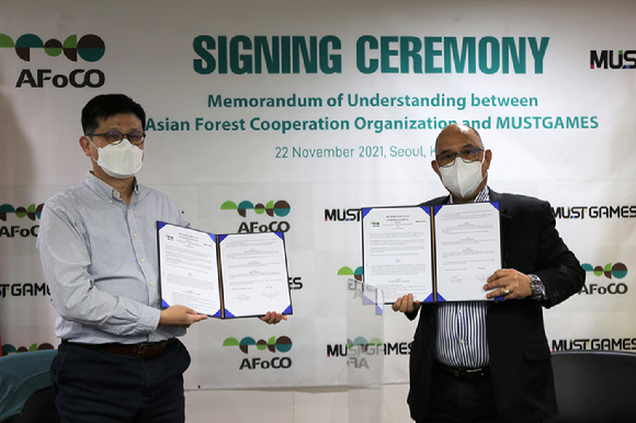 리카르도 칼데론 아시아산림협력기구 사무총장(오른쪽)과 강백주 머스트게임즈 대표(왼쪽)가 업무협약을 체결한 뒤 기념촬영을 하고 있다. [사진=산림청 ]