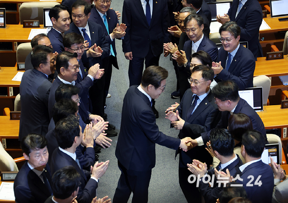 이재명 대통령이 26일 오전 서울 여의도 국회에서 열린 제426회국회(임시회) 제2차 본회의에서 2025년도 제2회 추가경정예산안 시정연설을 위해 본회의장으로 들어서며 의원들과 인사나누고 있다. [사진=국회사진기자단]