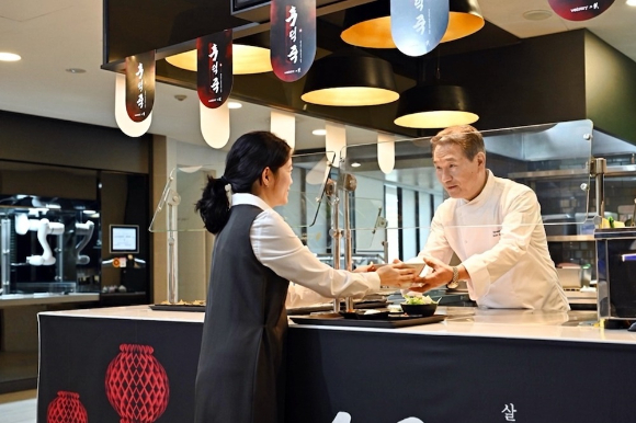 후덕죽 셰프가 삼성웰스토리 구내식당 이용 고객에게 프로모션 메뉴를 제공하고 있다. [사진=삼성웰스토리 제공]