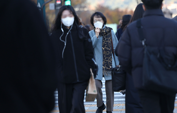 중부지방에 0도 안팎의 추위가 이어지는 지난 19일 오전 서울 광화문광장에서 시민들이 마스크를 착용한 채 걸어가고 있다. [사진=연합뉴스]