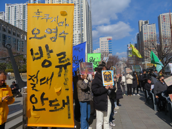 지난 21일 부산시청 앞 광장에서 열린 '부산고리2호기 수명연장·핵폐기장 반대 범시민운동본부' 발족 기념 집회에서 환경운동가가 '후쿠시마 원전수 방류 절대 안돼'라고 적힌 시위 깃발을 들고 서 있다. [사진=뉴시스]