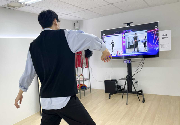 김 선임연구원이 스마트폰을 TV와 연결한 채 KT 리듬댄스를 시연하고 있는 모습. [사진=KT]