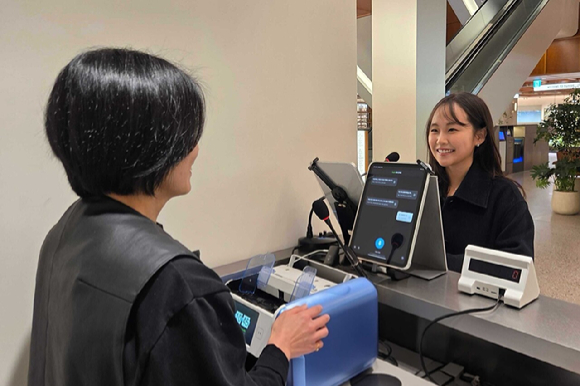 서울 강남구에 위치한 하우스오브신세계 청담점에서 고객 응대 데스크에 방문한 고객이 직원과 챗 트랜스레이션 엔터프라이즈를 통해 글로벌 소통하고 있다. [사진=플리토]