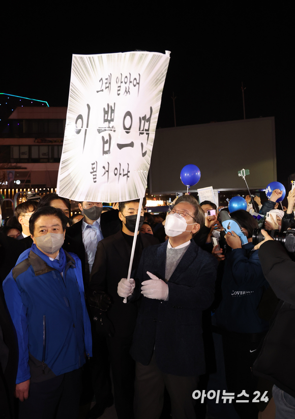 공식 선거운동 마지막 날인 8일 저녁 이재명 더불어민주당 대선후보가 서울 마포구 홍대 걷고싶은거리를 찾아 '절박재명, 가보자고!' 마지막 유세를 펼치는 중 지지지가 건낸 '그래 알았어 이 뽑으면 될 거 아냐' 응원 문구를 보며 웃고 있다.[사진=국회사진취재단]