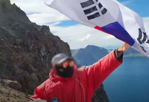 한 유튜버가 백두산 천지에서 태극기를 흔들다 제지당했다. [사진=유튜브 '시수기릿' 캡처]