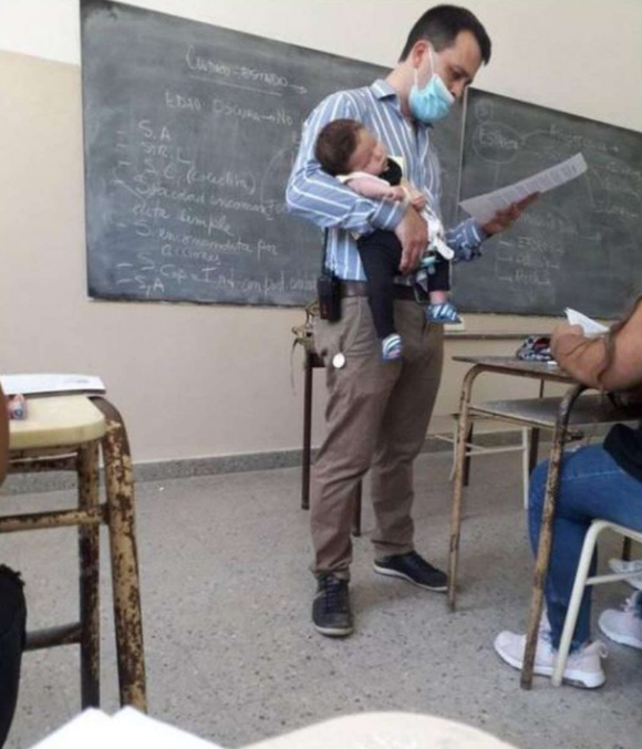교사가 한 손에는 아이를 다른 한 손에는 교재를 들고 수업을 진행하고 있다 [사진=루드미아 디산테 페이스북]
