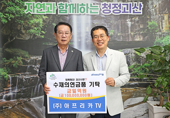 아프리카TV 서수길(오른쪽) CBO가 23일 괴산군청에서 송인헌 군수에게 1억 원 상당의 수재의연금품 증서를 전달하고 있다. [사진=괴산군]