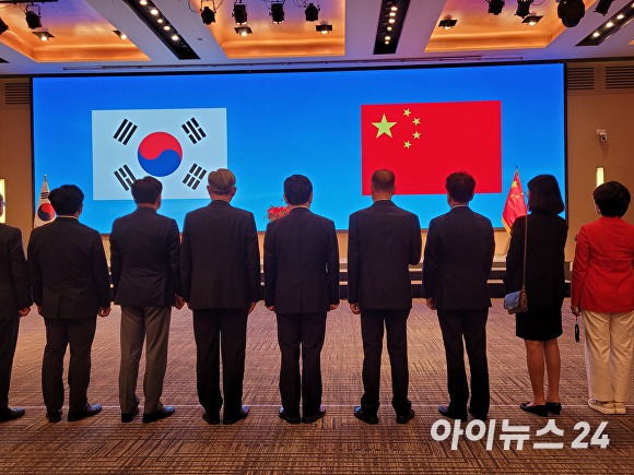 중화인민공화국 창립 74주년 경축리셉션에 참석한 관계자들이 양국 국기에 대해 경례를 하고 있다. [사진=박태진 기자]