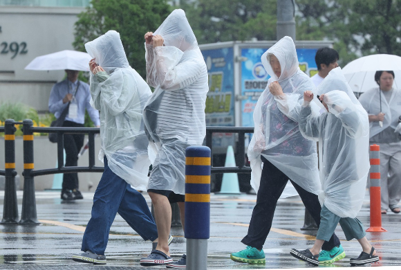 부산 해운대구 구남로에서 비옷을 입은 관광객들이 발걸음을 옮기고 있다. [사진=연합뉴스]