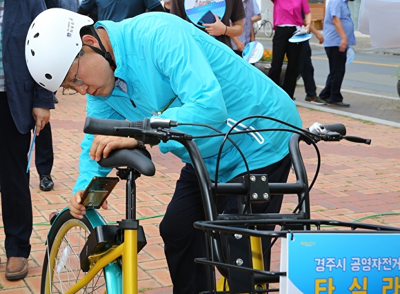 지난 7일 경주 봉황대 앞 광장에서 열린 공영자전거 개통식에 참석한 주낙영 경주시장이 스마트폰 앱으로 타실라를 대여하고 있다. [사진=경주시청]