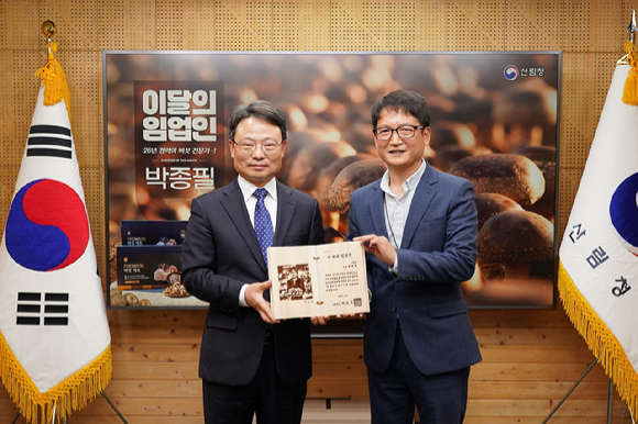 박은식 산림청장(왼쪽)이 13일 이 달의 임업인 박종필 그린팜 대표(오른쪽)에게 상패를 수여하고 있다 [사진=산림청 ]