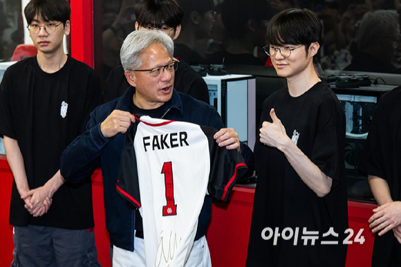 젠슨 황 엔비디아 최고경영자(CEO)가 5일 서울 마포구 &lsquo;T1 베이스 캠프&rsquo;를 방문해 &lsquo;페이커&lsquo; 이상혁을 비롯한 e스포츠 구단 T1의 리그 오브 레전드(LoL) 선수단을 만나서 &lsquo;페이커&rsquo;의 사인이 담긴 기념품을 선물 받고 있다. [사진=곽영래 기자]