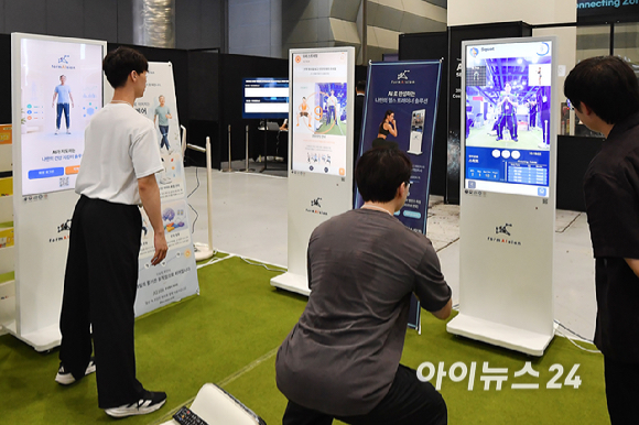 19일 서울 강남구 코엑스에서 열린 '2026 AI 서밋 서울 앤 엑스포(AISE 2026)'에서 관람객들이 부스에서 체형 분석 및 동작 코칭 AI 체험을 하고 있다. [사진=곽영래 기자]