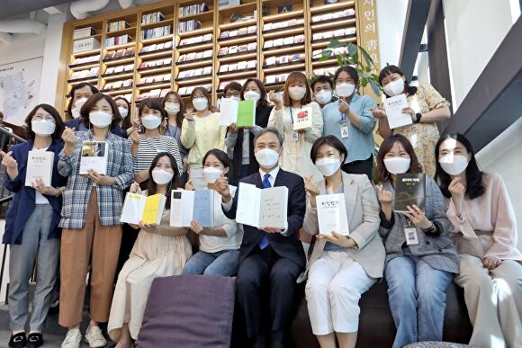 김승수 전주시장(앞줄오른쪽4번째)이 동문 헌책도서관 관계자들과 책을 들고 손가락하트를 만들고 있다. [사진=전주시]