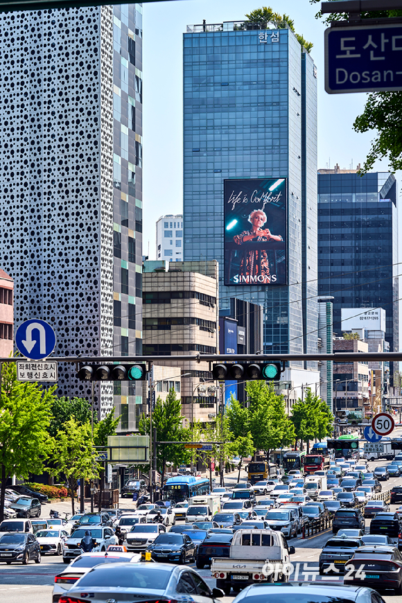 수면 전문 브랜드 시몬스가 서울 강남구 도산대로 일대에서 2026 브랜드 캠페인을 전개한다. 6일 도산대로의 고층 빌딩 사이로 신규 브랜드 캠페인 '라이프 이즈 컴포트(LIFE IS COMFORT)' 영상이 상영되고 있다. [사진=정소희 기자]