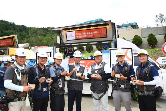 김승모 한화 건설부문 대표이사가 건설현장 근로자들과 'Summer Safety 푸드트럭 '팥빙수를 먹고 있다 [사진=한화 건설부문]