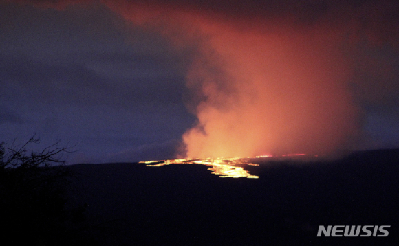 28일 새벽(현지시간) 미 하와이주 빅아일랜드에 있는 마우나로아 화산에서 용암이 흘러내리고 있다. 세계 최대 활화산인 마우나로아 화산이 용암과 함께 화산재 등을 분출하면서 미 지질조사국(USGS)은 인근 지역 주민들에게 추가 분출 상황에 대비할 것을 당부했다. [사진=뉴시스 ]