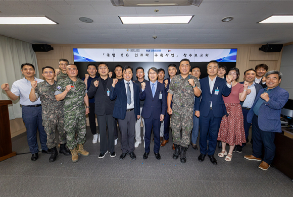 KT Enterprise부문 이행1본부장 이진권 상무(앞줄 왼쪽부터 6번째)와 국방부, 한국지능정보사회진흥원(NIA) 주요 관계자가 ‘국방 5G 인프라 구축’ 사업 착수보고회에서 단체 기념사진을 촬영하는 모습 [사진=KT]