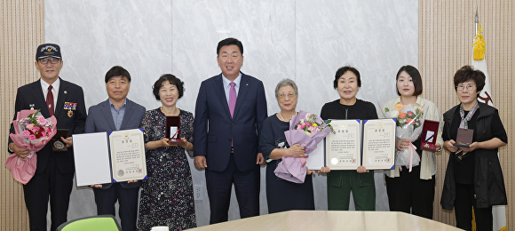 이범석 청주시장(왼쪽 네번째)이 6·25 전쟁 참전용사 고 정월근 중사 등 유족에게 무공훈장을 전달한 뒤 함께 사진을 찍고 있다.  [사진=청주시]