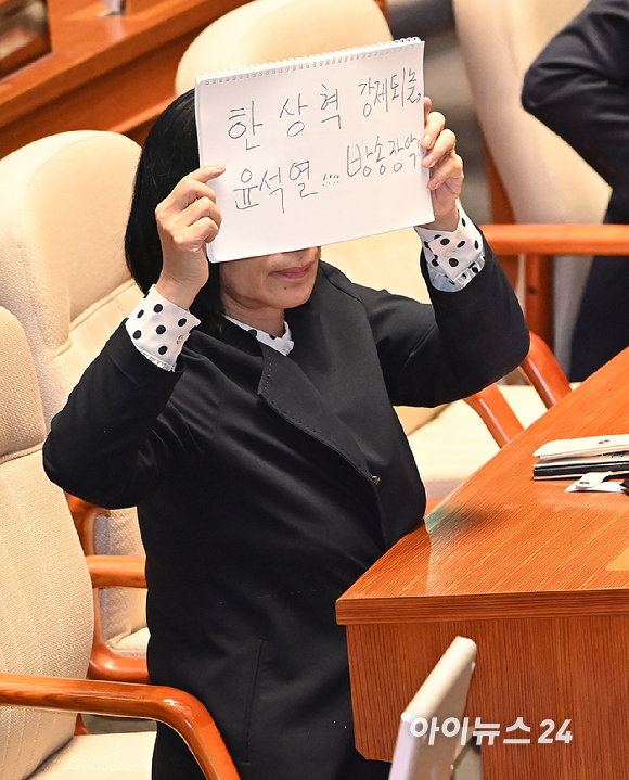 최민희 국회 과학기술정보방송통신 위원장이 18일 서울 여의도 국회에서 열린 본회의에서 이진숙 방송통신위원장에 대한 교육&middot;사회&middot;문화에 관한 질문 중 '한상혁 강제퇴출, 윤석열 방송장악' 이라고 쓴 손팻말을 들어 보이고 있다. [사진=곽영래 기자]