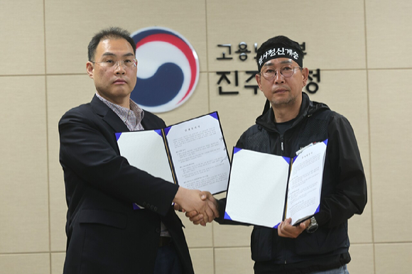 민주노총 화물연대와 BGF로지스가 30일 오전 경남 진주시 고용노동부 진주지청에서 단체합의서 조인식을 했다. 사진은 이민재 BGF로지스 대표이사(왼쪽)와 김동국 화물연대 위원장이 기념 촬영을 하는 모습. [사진=연합뉴스]