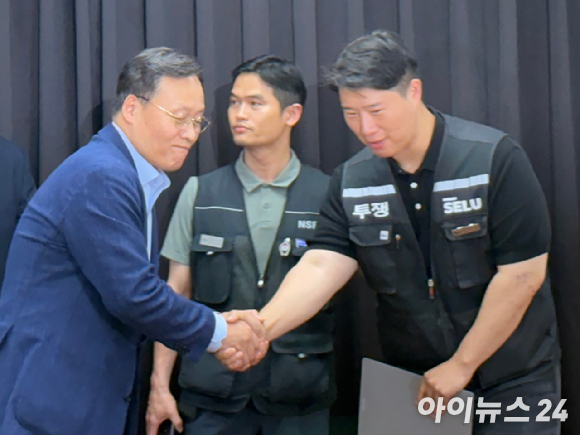 여명구 삼성전자 부사장(외쪽)과 최승호 초기업노조 삼성전자 지부 위원장이 지난 20일 밤 10시 44분경 수원 경기고용노동청에서 열린 노사 대화를 마치고 손을 맞잡고 있다. [사진=권서아 기자]