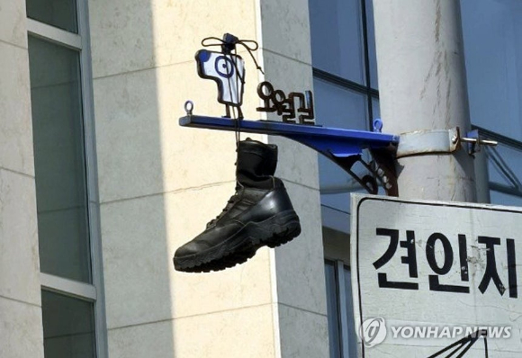 30일 오후 광주 동구 대인동 광주은행 본점 인근 교차로 전봇대에 군화가 걸려 있다.군화를 수거한 광주시와 5&middot;18 기념재단은 누가, 어떠한 의도로 군화를 걸어뒀는지 자체 조사에 착수했다. 2026.6.30 [사진=5&middot;18 기념재단/연합뉴스]