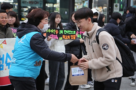 현대제철 당진제철소 마중물 봉사단원이 지역 수험생에게 생수와 핫팩을 전달하고 있다  [사진=현대제철]