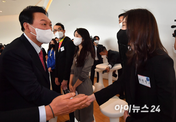 윤석열(왼쪽) 대통령 당선인이 27일 서울 동대문디자인플라자(DDP)에서 열린 '문화예술체육 인사들과의 오찬'에 참석해 쇼트트랙 국가대표 최민정과 인사를 나누고 있다. [사진=인수위사진기자단]