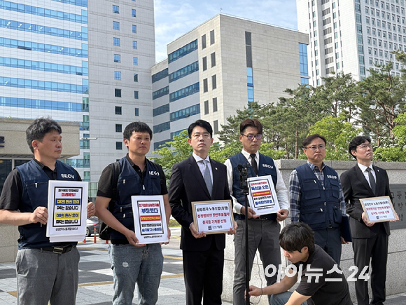 삼성전자노동조합 동행(SECU) 관계자들과 법률대리인인 강문혁 법무법인 대정 변호사(가운데)가 26일 오전 8시 40분경 경기 수원시 수원지방법원 앞에서 삼성전자 임단협 잠정합의안 찬반투표 절차 중지 가처분 신청 관련 기자회견을 하고 있다. [사진=권서아 기자]