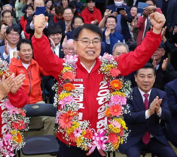 윤일현 국민의힘 금정구청장보궐선거 후보가 16일 오후 부산 금정구 선거사무소에서 당선이 유력해지자 꽃다발을 목에걸고 환호하고 있다. 2024.10.16 [사진=연합뉴스]