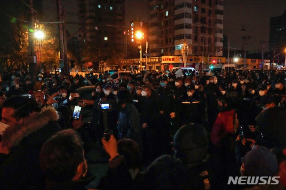 지난 27일 중국 베이징에서 코로나19 봉쇄 정책에 항의하는 시위대가 경찰과 대치하고 있다. 시민들은 정부에 항의하는 의미를 담은 ‘백지’를 들고 28일 새벽까지 시위를 이어갔다. [사진=뉴시스]