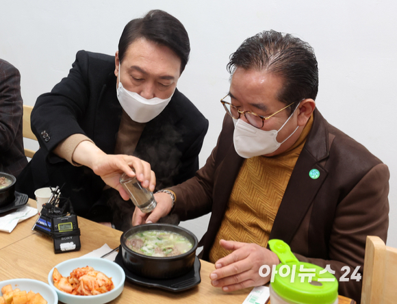 윤석열 대통령 당선인이 14일 당선 이후 첫 외부 공식일정으로 서울 남대문 시장을 찾아 상인회 회장단과 간담회를 마친 뒤, 식당으로 이동해 한 상인회 회장의 갈비탕에 후추를 뿌려주고 있다. [사진=국회사진취재단]