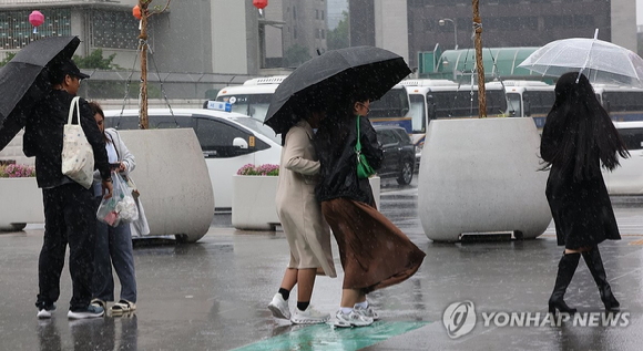 서울 광화문광장 부근에서 우산을 든 외국인 관광객들이 비바람을 맞으며이동하고 있다. [사진=연합뉴스]
