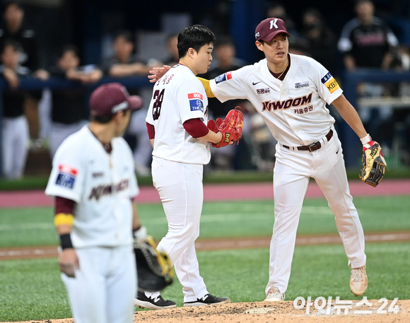 27일 서울 고척스카이돔에서 '2022 신한은행 MY CAR KBO리그' 플레이오프 3차전 키움 히어로즈와 LG 트윈스 경기가 열렸다. 키움 김재웅이 8회초 무사 1,2루 상황에서 LG 문보경의 희생번트 때 다이빙 캐치로 더블아웃을 만든 후 송성문에게 격려를 받고하고 있다. [사진=김성진 기자]