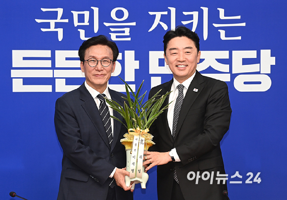 김민석 더불어민주당 신임 당대표가 18일 서울 여의도 국회에서 강훈식 대통령 비서실장으로부터 이재명 대통령 명의 축하 난을 전달받고 있다. [사진=곽영래 기자]
