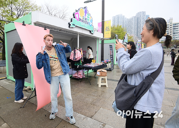 10일 서울 여의도 한강공원에서 열린 '2026 서울 스프링 페스티벌' 케이팝아케이드 부스에서 외국인 관광객이 포토카드 만들기 체험을 하고 있다. [사진=정소희 기자]