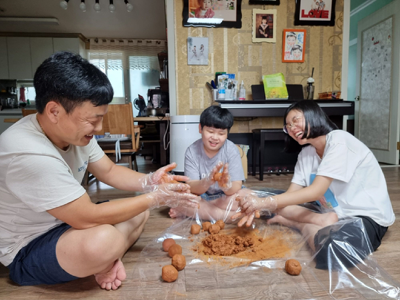 LG유플러스 임직원 가족이 EM흙공을 함께 만들고 있는 모습. [사진=LG유플러스 ]