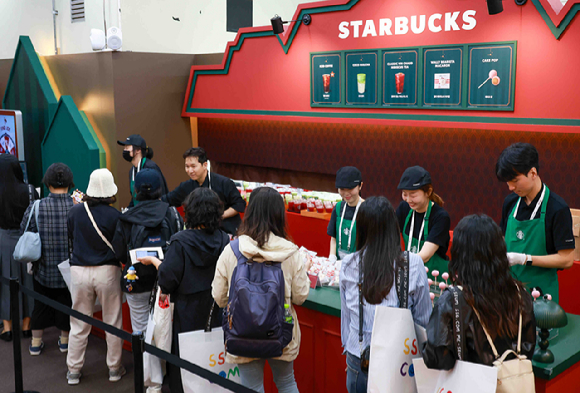 미지엄 행사장에서 미리 만나는 크리스마스를 콘셉트로 부스를 운영 중인 스타벅스가 30일 출시 예정인 크리스마스 프로모션 음료를 고객에게 제공하는 모습. [사진=스타벅스]