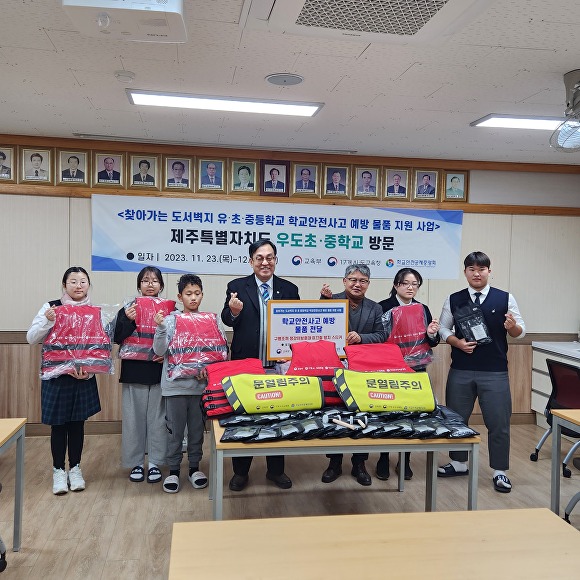 정훈 학교안전공제중앙회 이사장(왼쪽에서 네 번째)이 우도초·중자치회 학생들에게 물품을 전달하고 있다. [사진=제주특별자치도교육청]