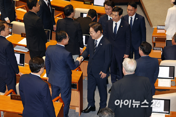 이재명 대통령이 26일 오전 서울 여의도 국회 본회의장에서 추가경정예산안(추경안) 시정연설을 마친 뒤 국민의힘 의원들과 인사를 나누고 있다. [사진=국회사진기자단]