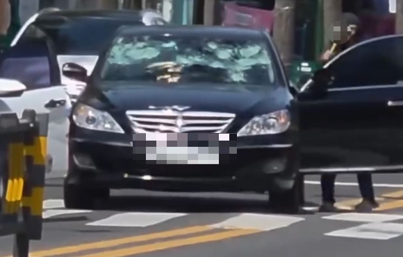 도로 한복판에서 차량 앞유리 등에 고무망치를 휘두른 50대 남성이 경찰에 붙잡혔다. 사진은 A씨 범행 모습. [사진=온라인 커뮤니티]