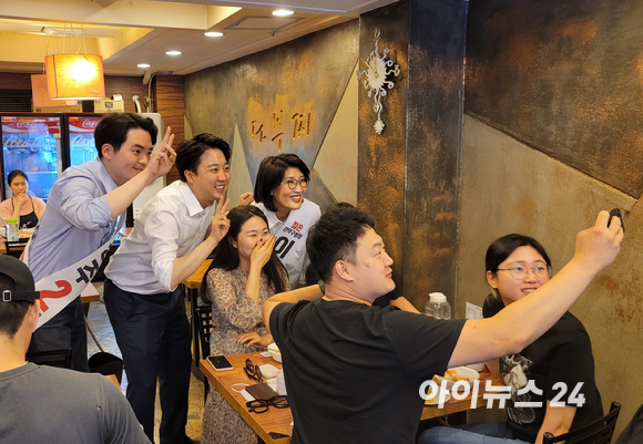 이준석 국민의힘 대표가 24일 서울 관악 대학동의 한 식당에서 지역 출마자, 주민들과 함께 사진을 촬영하고 있다. [사진=정호영 기자]