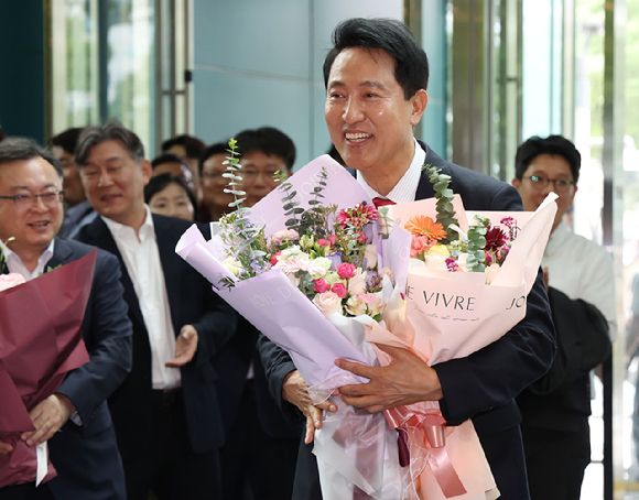 오세훈 서울시장이 시장 업무에 복귀한 4일 서울시청 로비에서 꽃다발을 받은 뒤 기뻐하고 있다. [사진=연합뉴스]