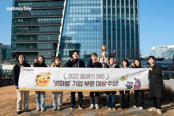 임현섭 넷마블 뉴미디어 팀장(왼쪽에서 네 번째)과 뉴미디어 팀원들이 서울시 구로구에 위치한 넷마블 사옥 지타워에서 '2022 올해의 SNS' 대상 수상을 기념해 사진촬영을 하고 있다. [사진=넷마블]
