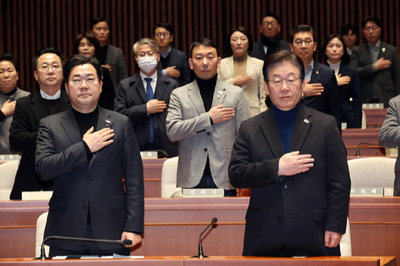 더불어민주당 이재명 대표와 박찬대 원내대표가 8일 서울 여의도 국회에서 열린 비상 의원총회에서 국기에 대한 경례를 하고 있다. 2025.3.8 [사진=연합뉴스]